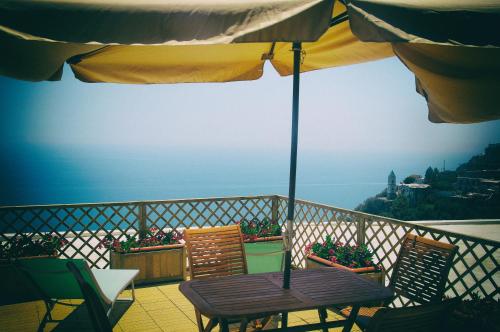 a table and chairs on a balcony with an umbrella at Casa Martina in Amalfi