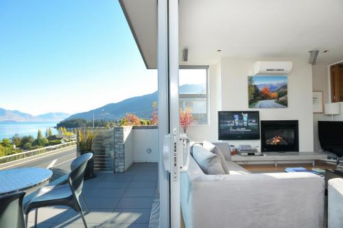 a living room with a view of the water at Swiss-Belsuites Pounamu Queenstown in Queenstown