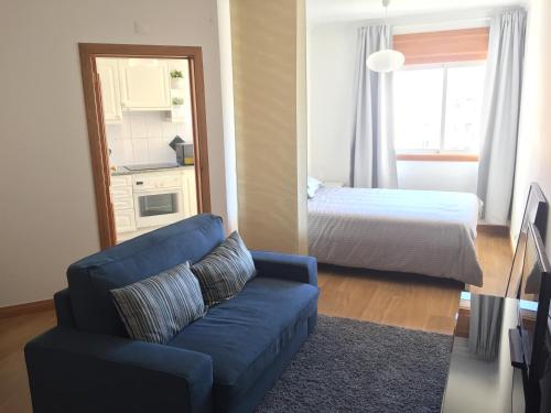 een woonkamer met een blauwe bank en een bed bij 8-bit-building in Lissabon