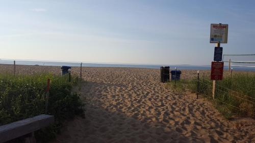 a sandy beach with a fence and signs on it at The Inn at Soho Square in Old Orchard Beach