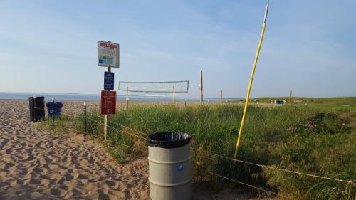 a volleyball net on a beach with a trash can at The Inn at Soho Square in Old Orchard Beach