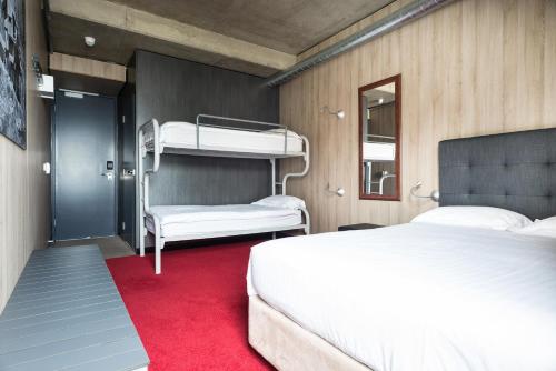 sypialnia z 2 łóżkami piętrowymi i czerwonym dywanem w obiekcie Buller Central Hotel w mieście Mount Buller