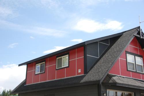 uma casa vermelha e preta com um telhado cinzento em Fieldstone Guesthouse em Clearwater