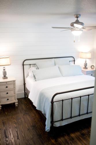 a bedroom with a bed with white sheets and two lamps at Stonehill Cottages in Mena