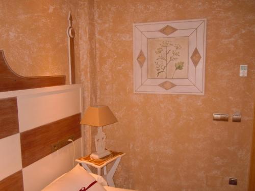 a bedroom with a bed and a lamp on a table at Posada La Torre de los Isla & Spa in Beranga