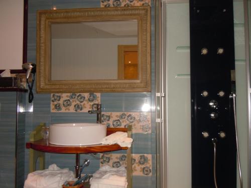 a bathroom with a mirror and a table with towels at Posada La Torre de los Isla & Spa in Beranga