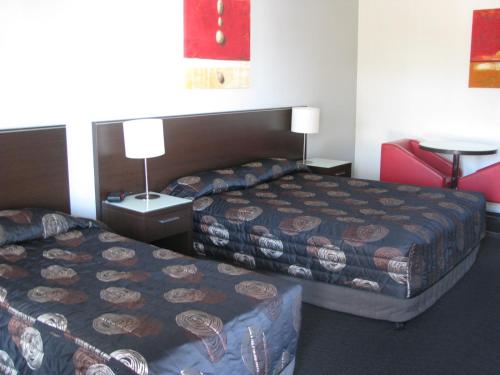 una camera d'albergo con due letti e un tavolo di Gympie Muster Inn a Gympie
