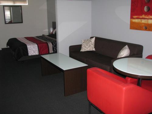 a room with a couch and a bed and a table at Gympie Muster Inn in Gympie