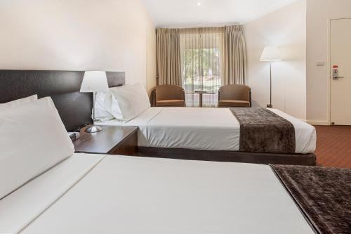 Cama ou camas em um quarto em Karratha International Hotel