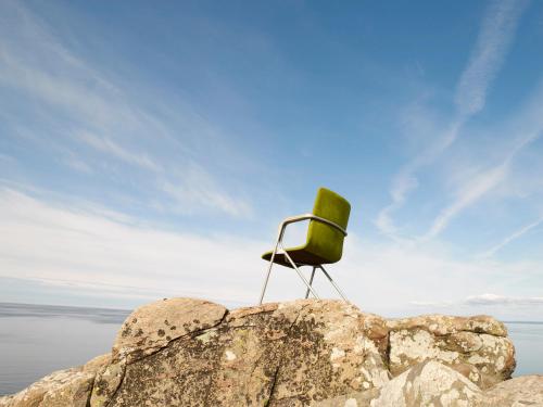 a chair sitting on top of a rock at Hotell och Restaurang Hovs Hallar in Båstad