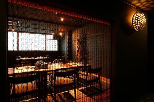a dining room with tables and chairs and a window at Tabinoyado Ushionoakari Geiboso in Shima
