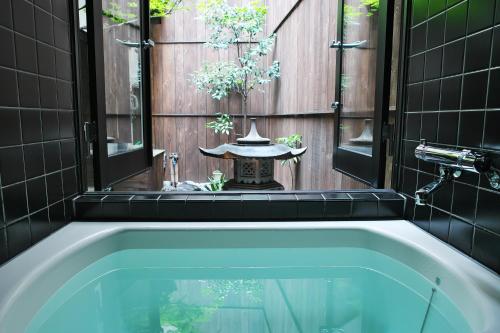 a bath tub in a bathroom with a chineseificialificialificialificialificialificial at Komachiya in Kyoto