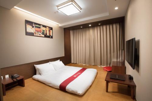 
A bed or beds in a room at Ramada by Wyndham Jeonju
