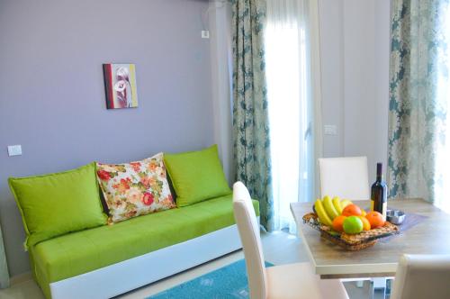 een woonkamer met een groene bank en een tafel bij Apartments Ambassador in Ulcinj