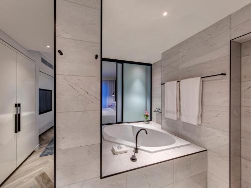 a bathroom with a sink, mirror and bathtub at The Star Grand Hotel and Residences Sydney in Sydney