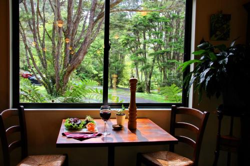 a table with two glasses of wine in front of a window at Rapaura Watergardens in Tapu