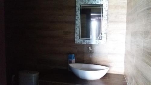 a bathroom with a white bath tub and a mirror at Bunutbali Villas88 in Nusa Lembongan