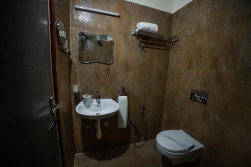 a bathroom with a toilet and a sink at Hotel Lemon Stay in Yercaud