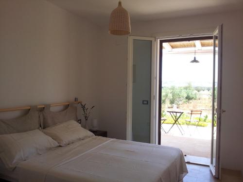 a bedroom with a bed and a sliding glass door at B&B Sosta A Ponente in Matino