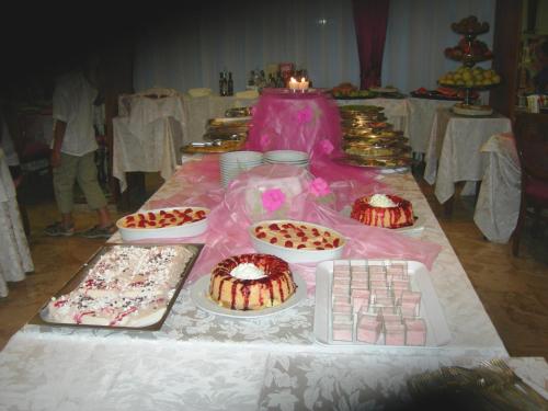 a table with many cakes and other desserts on it at Hotel Gioiella Depandance in Bellaria-Igea Marina
