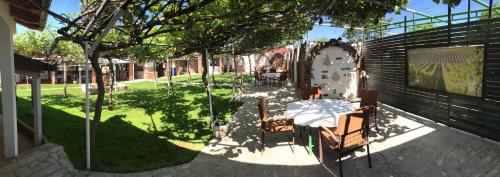 a patio with a table and chairs in a yard at Motel Kiwi in Grude