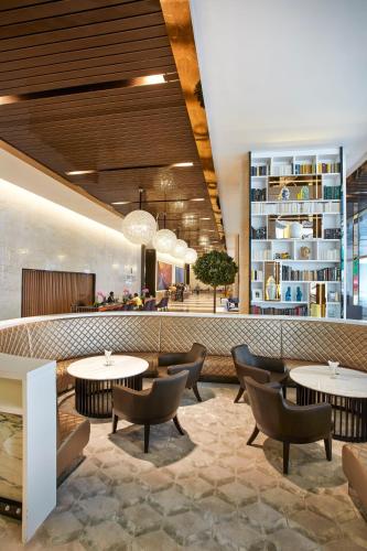 a lobby of a restaurant with tables and chairs at THE FACE Suites Hotel in Kuala Lumpur
