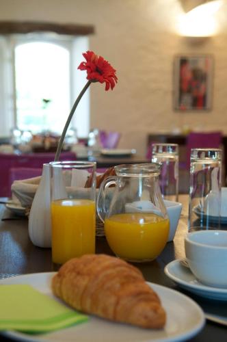 a table with a plate of bread and two glasses of orange juice at Terra Gasconha in Barbaste