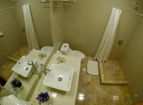 a bathroom with two sinks and a toilet and a shower at Casona Plaza Hotel Colonial in Arequipa