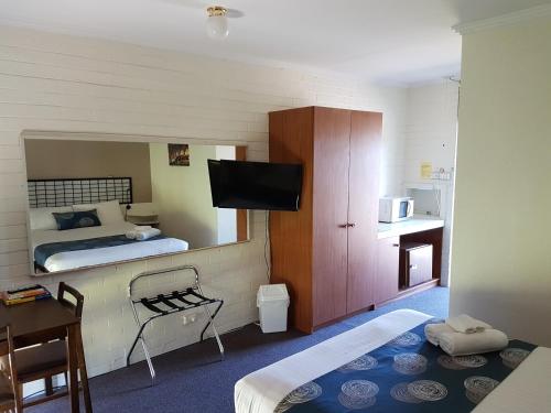 Habitación pequeña con cama y TV. en Motel Traralgon en Traralgon