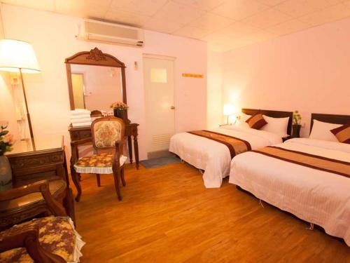 una camera d'albergo con due letti e uno specchio di Ideal Hot Spring Water Hotel a Jiaoxi