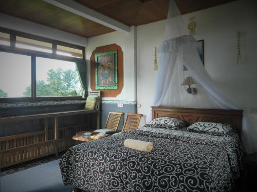 1 dormitorio con cama y ventana grande en Dau Homestay, en Tirtagangga