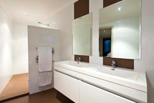a bathroom with two sinks and a large mirror at Blue Cliff Retreat in Pokolbin