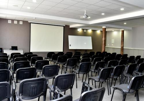 an empty room with chairs and a white screen at Skif HOTEL & SPA in Petropavlovsk
