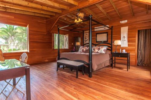 a bedroom with a bed in a room with wooden walls at Dream Valley Belize in Teakettle Village
