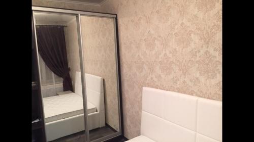 シャフティにあるApartment on prospekt Chernokozova 99Bのバスルーム(鏡、ベッド1台、バスタブ付)
