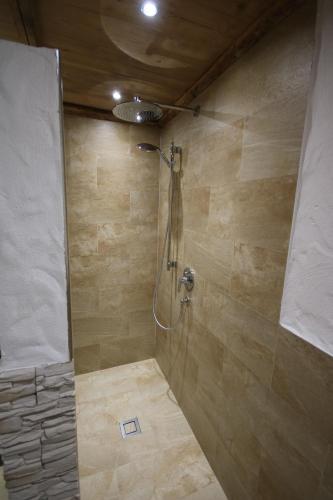 a bathroom with a shower with a stone wall at Appartementhaus Brunnenhof in Wagrain