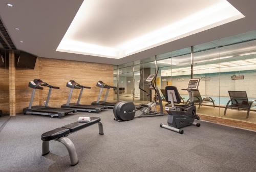 a gym with a bunch of exercise equipment in it at Ramada Plaza Qiandeng Kunshan in Kunshan