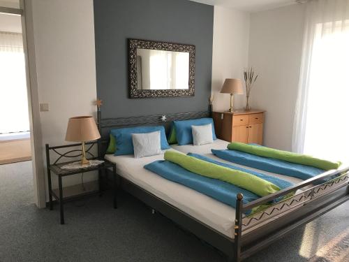 バート・ボックレットにあるAppartementhaus Laura-Sophiaのベッドルーム1室(大型ベッド1台、青と緑の枕付)