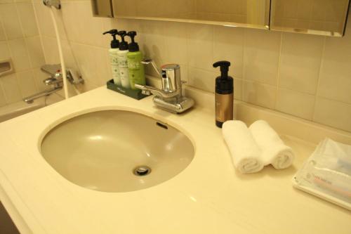 a bathroom sink with toiletries on top of it at Art Hotel Asahikawa in Asahikawa