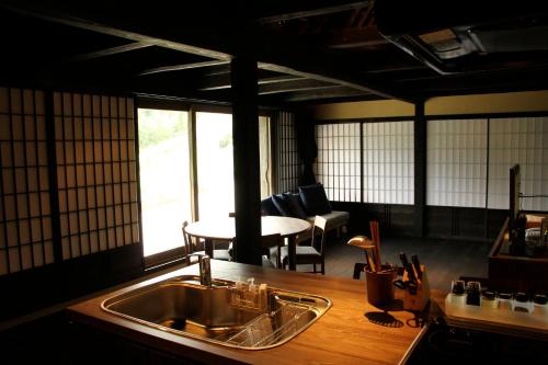 cocina con fregadero y mesa con sillas en Tougenkyo Iya no Yamazato, en Wakabayashi
