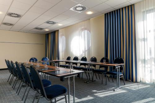 a conference room with tables and chairs and windows at Seminaris Hotel Nürnberg in Nürnberg