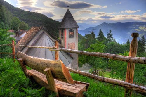 a small church in a field next to a fence at Bad St Isidor in Bolzano