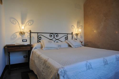 a bedroom with a bed with two lights on the wall at Villa Eugenia in Cairo Montenotte