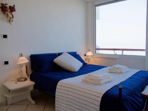 テルモリにあるSun, casa sul mareのベッドルーム1室(青いシーツと窓付)