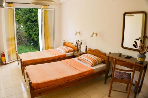 DhavgátaにあるCottage Sakkatosの鏡とテーブル付きの部屋にベッド2台が備わります。
