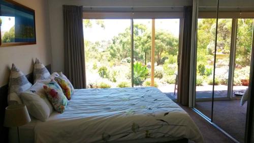 a bedroom with a bed with a large window at Austiny Bed and Breakfast Victor Harbor in Victor Harbor