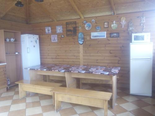 a kitchen with a table and benches and a refrigerator at FeoAlex in Koktebel