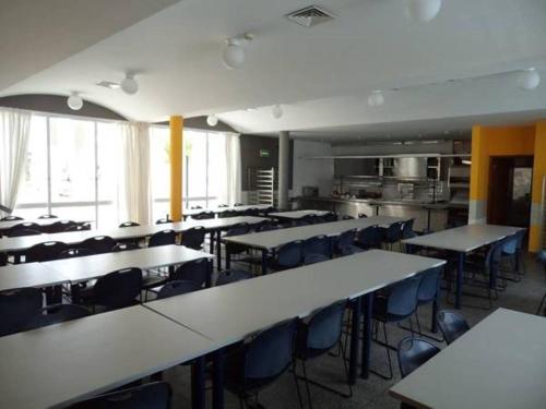 uma sala de aula com mesas e cadeiras e uma cozinha em HI Almograve – Pousada de Juventude em Almograve