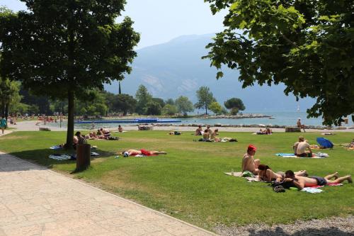 a group of people laying on the grass in a park at Hotel Sole Relax & Panorama in Riva del Garda