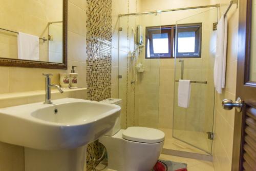 ein Bad mit einem Waschbecken, einem WC und einer Dusche in der Unterkunft Modern Thai Home in Ban Mae Mae